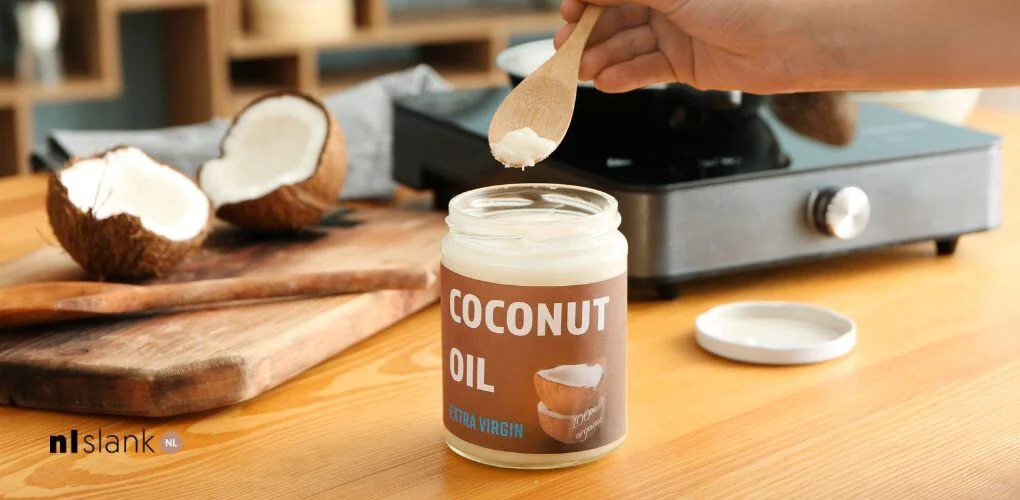 Pot kokosolie op een houten aanrecht, klaar voor gebruik bij het koken | Nederland Slank 